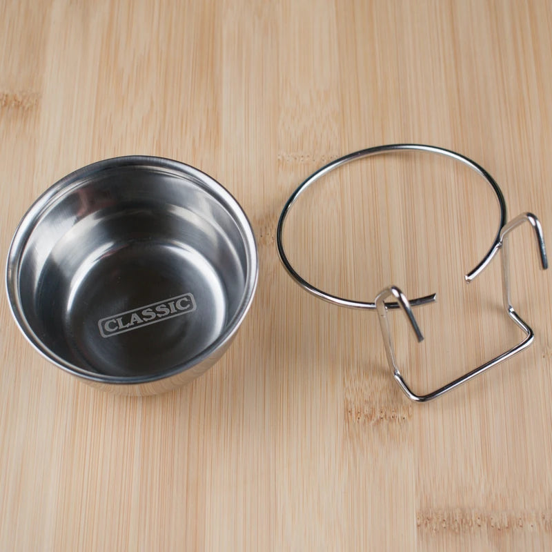 Stainless steel bowl with 'CLASSIC' branding and metal clip on a wooden surface