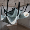 Pet hammocks with striped pattern and white lining hanging from a cage ceiling