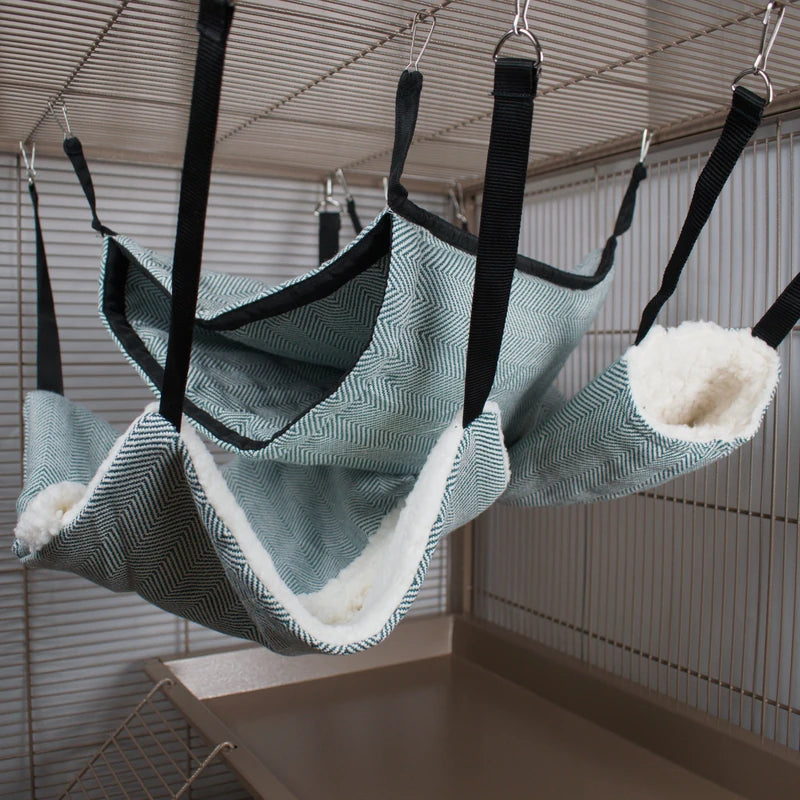 Pet hammocks with striped pattern and white lining hanging from a cage ceiling
