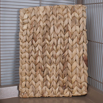 Woven mat with a braided pattern in a cage
