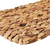 Close-up of a woven mat with natural brown tones on a white background