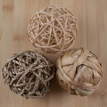 Three woven balls on a wooden surface