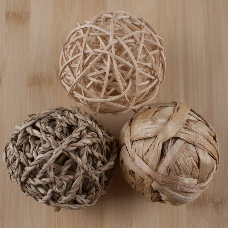 Three woven balls on a wooden surface